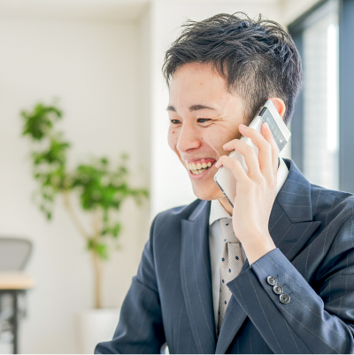 スーツを着て電話をしている笑顔の若い男性